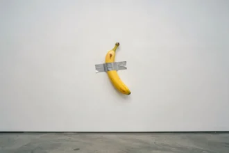 Banane collée au mur avec du scotch dans une galerie d'art contemporain, œuvre conceptuelle inspirée de Comedian de Maurizio Cattelan