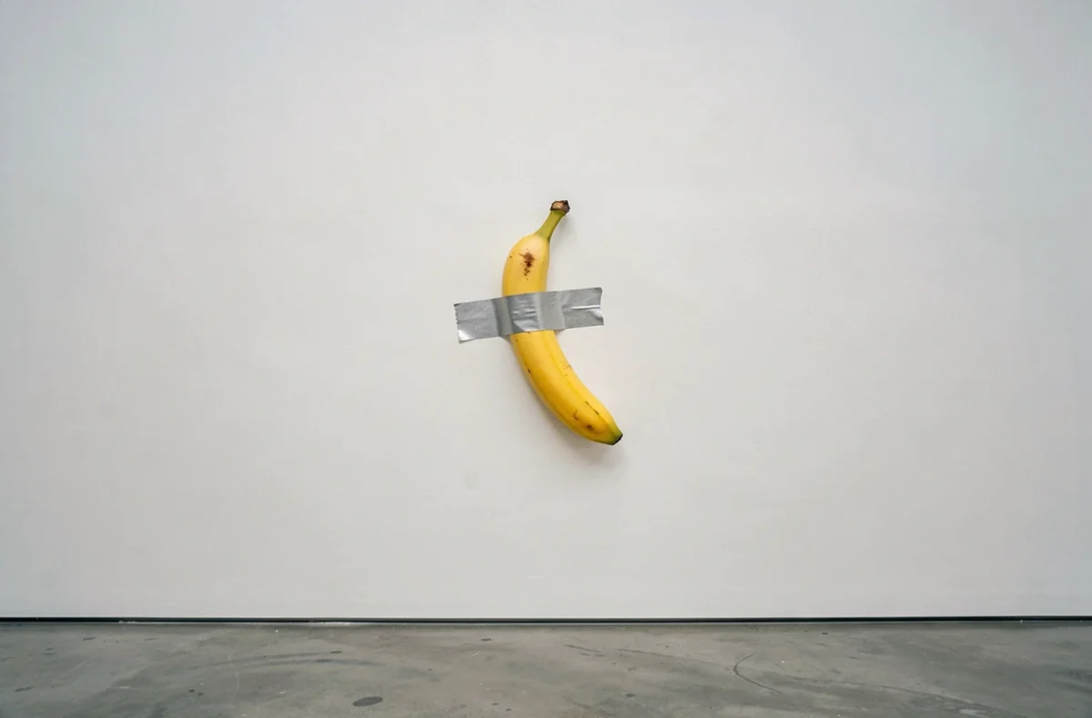 Banane collée au mur avec du scotch dans une galerie d'art contemporain, œuvre conceptuelle inspirée de Comedian de Maurizio Cattelan